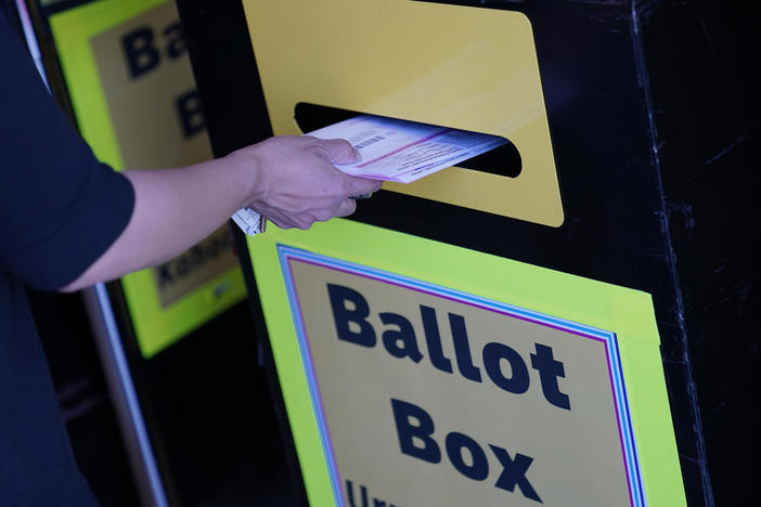 In this Oct. 29, 2020, file photo, a person places a mail-in ballot in a drop box at the Clark County Election Department in Las Vegas. As Republicans roll back access to the ballot, Democratic lawmakers have been quietly moving to expand voting rights.