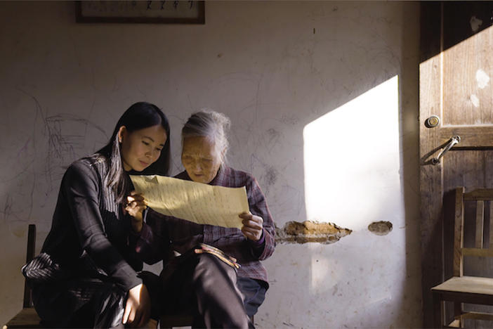 Two women examine a document.