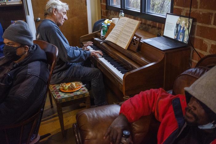 Randy Bedingfield plays the piano in a corner of the Daybreak Day Center during a reception celebrating the 10th anniversary in November of 2022 of the facility, which offers an array of services to the unhoused. Daybreak does not receive public money for their work. Bedingfield, a regular, says he found the center after his parents died. "It hit during a particularly difficult time for me," he said. 