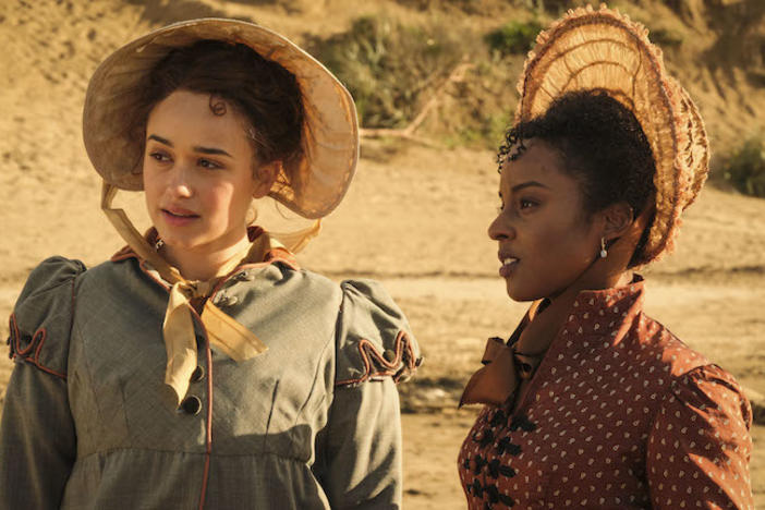 Cast of Sanditon in period dress on a beach.