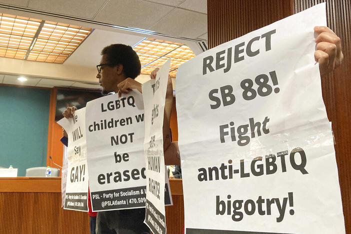 Protesters hold up signs opposing a bill regulating discussion of gender identity in schools on Wednesday, March 1, 2023, at the Georgia Capitol in Atlanta. The Senate Education and Youth Committee voted to table the bill after conservatives also expressed opposition. 