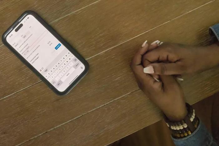 A cellphone on table with woman's hands