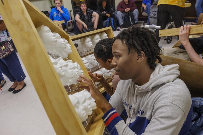 Georgia Academy for the Blind senior Daquan Brown with the 3d yearbook printed for him and other members of the Class of 2023 by Mercer University engineering students.