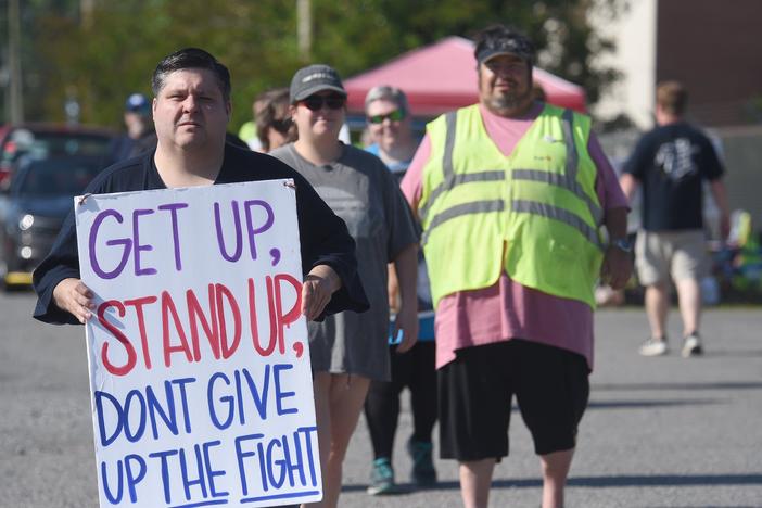 Chris Crowe, left, carries a sign during the protest by Amalgamated Transit Union Local 1212 in front of First Student in Dalton on Monday, May 15, 2023. Crowe is vice president of ATU Local 1212.