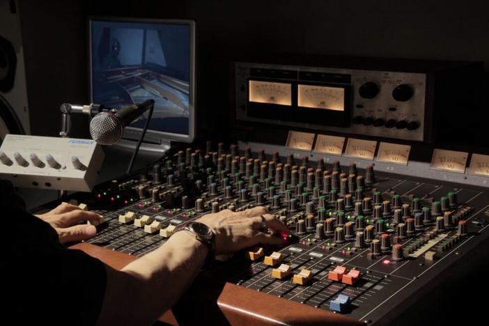 a sound engineer adjusts a mixing board