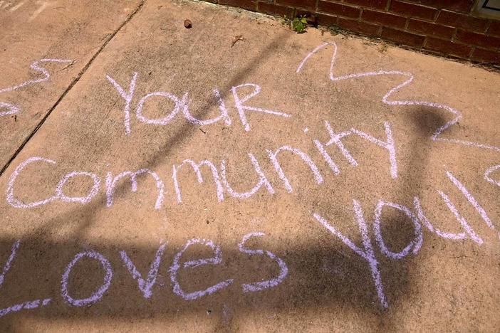 A chalk drawing reads “Your Communty Loves You” across from Temple Beath Israel as hundreds of people gather at for a counter-protest Saturday afternoon after an antisemitic hate group gathered outside the Temple Friday. 