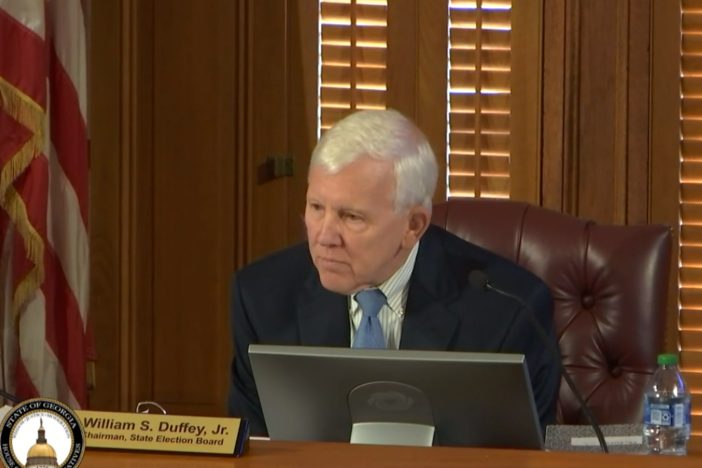 William Duffey is shown speaking as chairman of the State Election Board.