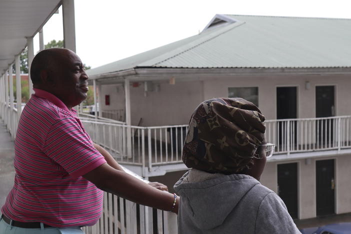 Dana Williams and his daughter De'mai Williams stand outside a low-cost hotel in Atlanta on May 18, 2023. The two have been looking for an affordable place to live ever since they were evicted from their two-bedroom apartment in April. 