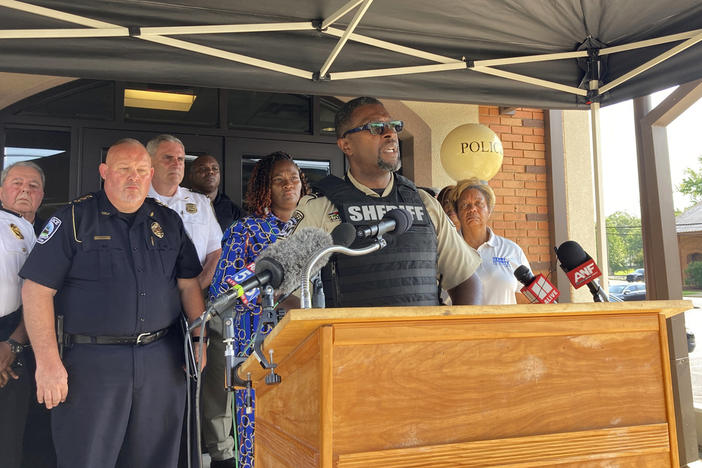 Henry County Sheriff Reginald Scandrett speaks on Sunday, July 16, 2022, in Hampton, Ga, while flanked by other police and local officials. Scandrett announced that officers shot and killed Andre Longmore on Sunday, a day after officials say Longmore shot and killed four Hampton residents.