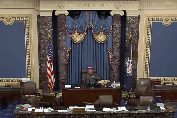 This image from U.S. Senate video, introduced at the trial of Bruno Joseph Cua, shows Cua sitting with his feet up in the Senate chamber on Jan. 6, 2021, during the riot at the U.S. Capitol. Cua, who stormed the U.S. Capitol, assaulted a police officer and sat in a Senate floor chair reserved for the vice president was sentenced on Wednesday, July 26, 2023, to one year in prison.