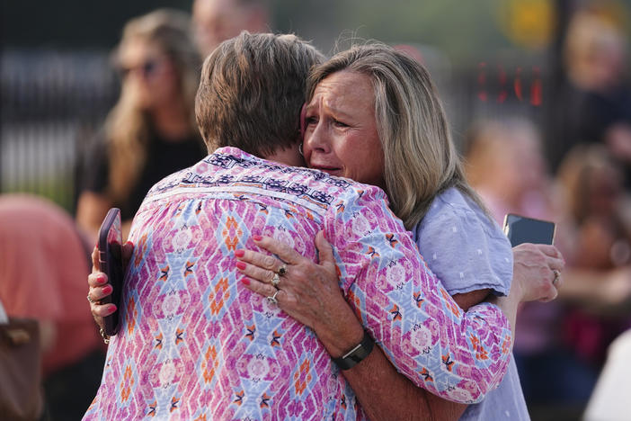Gaylan Blizzard, right hugs a woman during a vigil for the victims of Saturday's mass shooting on Monday, July 17, 2023, in Hampton, Ga. 