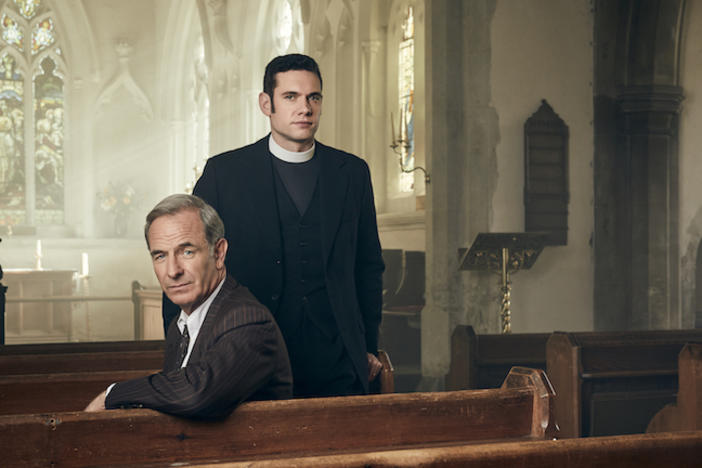 The stars of Grantchester sitting in a church.