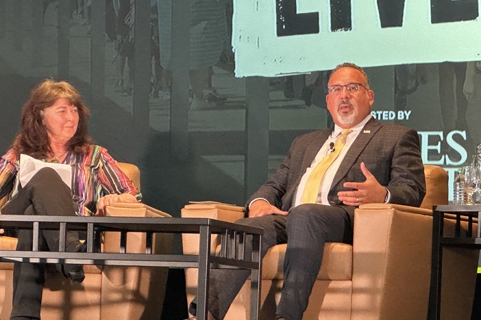 U.S. Education Secretary Miguel Cardona (right) spoke at Agnes Scott College on July 17 as part of an event moderated by The Atlanta Journal-Constitution's Maureen Downey.
