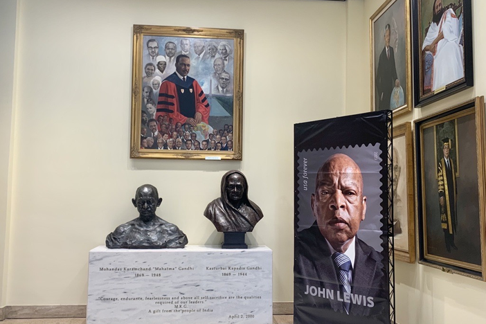 A banner featuring the John Lewis stamp sits next to a painting of Martin Luther King, Jr. and a bust of Gandhi at Morehouse College in Atlanta on July 21, 2023.