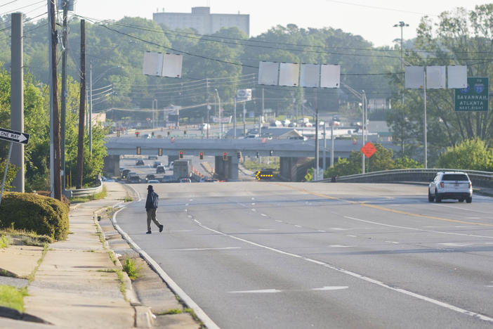 A man crosses in the middle of Spring Street in Macon where another man was killed just hours earlier. Four pedestrians have been killed in the area since 2006. Another 11 have died on a six mile stretch of the same highway in the same time frame. 