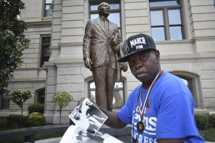  Singer and Civil Rights activist “General” Larry Platt shares photos and stories next to a statue of Martin Luther King Jr. at the Georgia Capitol.