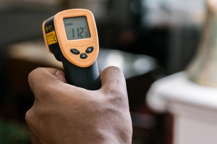 Using an infrared thermometer to measure the heat put out by an LED light bulb. 