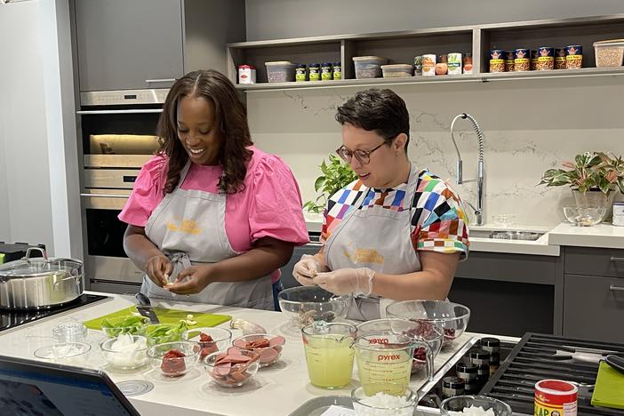 Leanna Pierre and Kristin Elliot prepare ingredients for a red beans and rice dish.