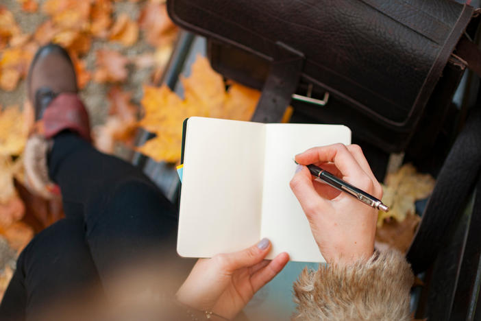 Someone writing with a pen on a page