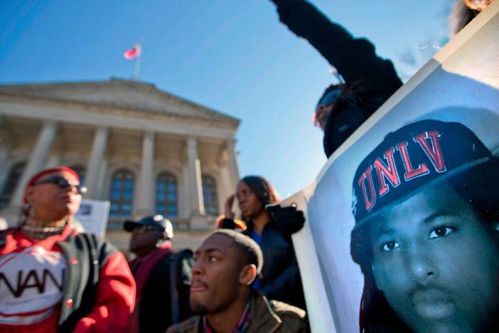 An image of Kendrick Johnson, the south Georgia teenager officials said was found dead inside a rolled-up wrestling mat in his school, is displayed on a banner, as demonstrators attend a “Who Killed K.J.” rally in Atlanta.
