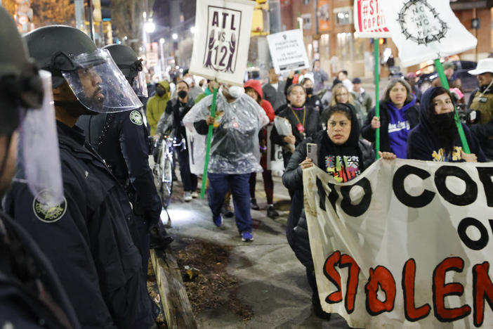 Demonstrators march near Atlanta police during a protest over plans to build a new police training center, Thursday, March 9, 2023, in Atlanta. A prosecutor on Friday, Oct. 6, says no charges will be sought against Georgia state troopers who shot and killed an activist at the site of a planned police and firefighter training center near Atlanta. 