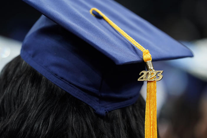 A tassel with 2023 on it rests on a graduation cap as students walk in a procession for Howard University's commencement in Washington, Saturday, May 13, 2023. 