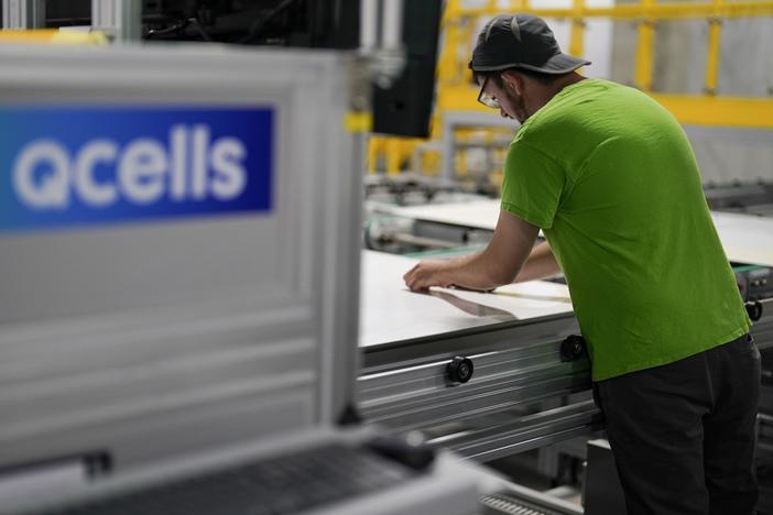 An employee works on a solar panel inside the Hanwha Qcells Solar plant, Monday, Oct. 16, 2023, in Dalton, Ga. The Korean company is opening what it says is the first solar panel factory to begin production in the U.S. since the passage of President Joe Biden’s signature climate legislation.