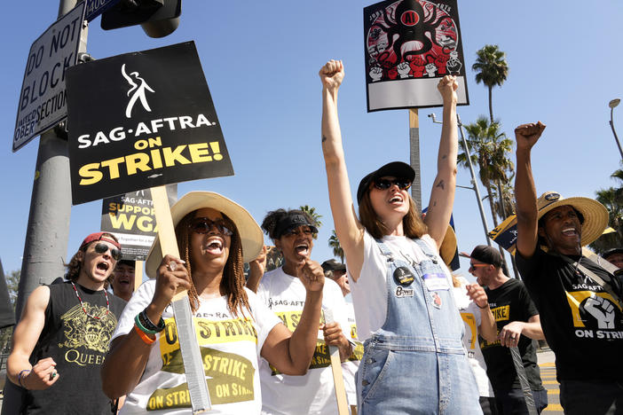 Striking actors Jennifer Leigh Warren, left, and Emily Kincaid, right, demonstrate outside Netflix studios, Tuesday, Oct. 17, 2023, in Los Angeles.