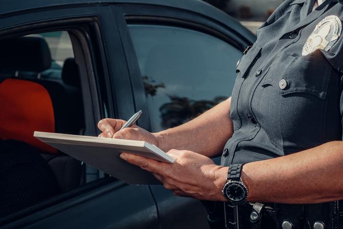 Close up of a police officer writing a speeding ticket.