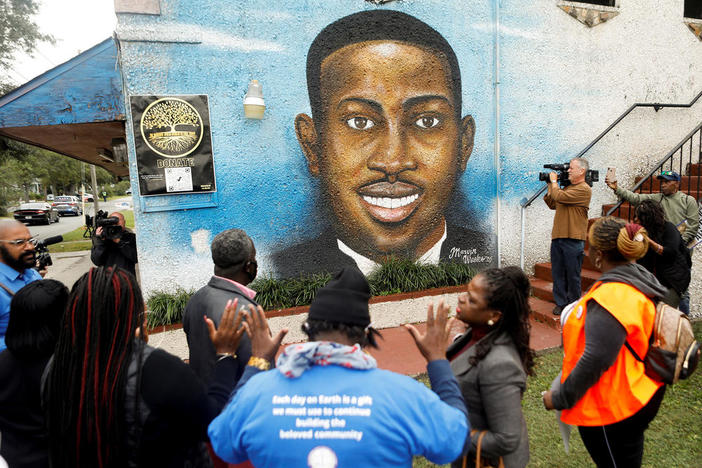 People gather in front of a mural of Ahmaud Arbery painted on the side of The Brunswick African American Cultural Center demanding justice for Ahmaud Arbery in Brunswick, Georgia, November 4, 2021. 