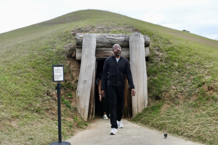 Senator Raphael Warnock exits the Earth Lodge, a relic of Mississippian culture from over 1,000 years ago, during his tour of the Ocmulgee National Historic Park.