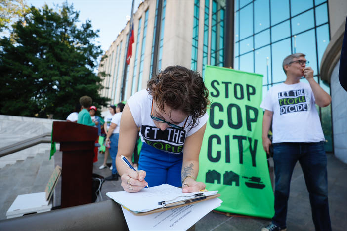 Activists gather outside Atlanta City Hall, Monday, Sept. 11, 2023, where they delivered dozens boxes full of signed petitions to force a referendum on the future of a planned police and firefighter training center. An analysis of petition entries by four news organizations finds it’s unclear whether petitioners have enough valid entries to force the citywide vote, with nearly half the entries unable to be matched to eligible registered Atlanta voters.