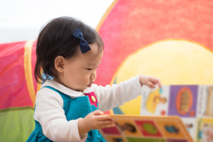 A baby explores a book