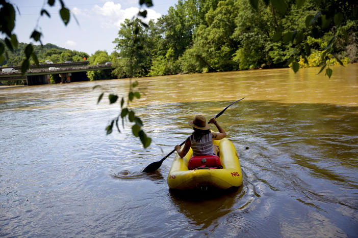 Brittany Martin floats down the Chattahoochee river as traffic spans Interstate 285 in Atlanta, Wednesday, June 27, 2018.