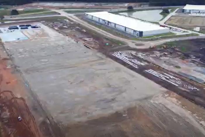 An aerial image of a warehouse under construction is shown.