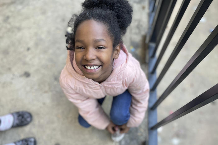 Tameka's 8-year-old daughter ties her shoe before running out to play in Atlanta on Dec. 5, 2023. The little girl should be in second grade but has never attended school. Tameka's kids have essentially been out of school since COVID hit in March 2020. They have had a consistent place to live, but nearly everything else in their lives collapsed during the pandemic. 