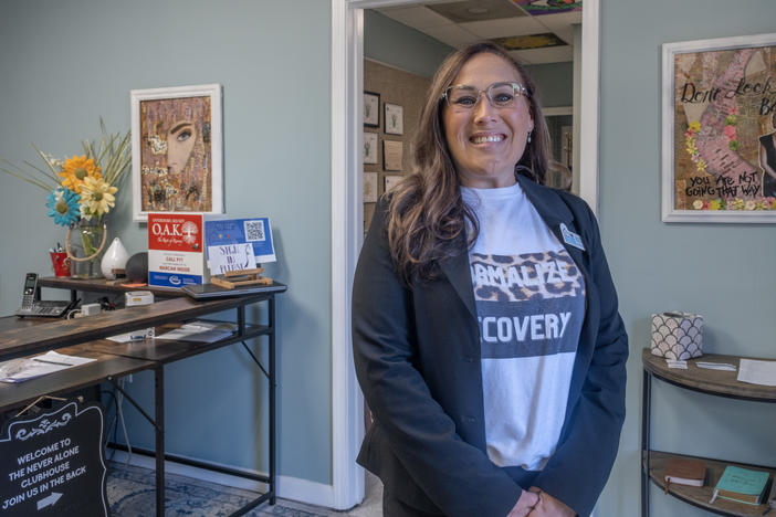 Jocelyn Wallace, executive director of The Never Alone Clubhouse, stands at the entrance of the recovery center in Douglas County. As someone in recovery herself, she opened this place two years ago to give people who have dealt with substance use disorder a chance to connect