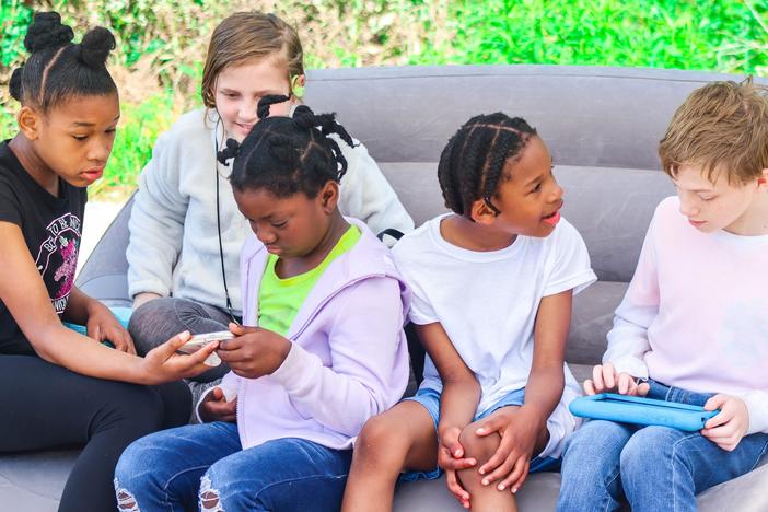 A group of five children talking