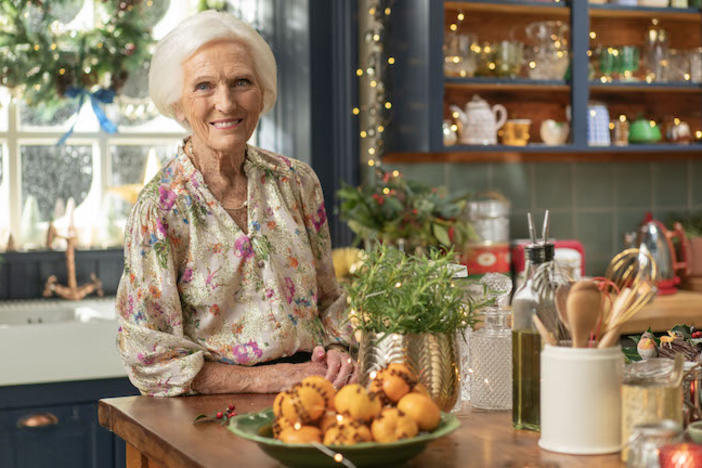 Mary Berry in a kitchen filled with food and Christmas decorations.