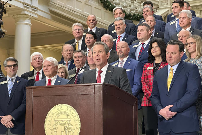 Georgia Gov. Brian Kemp, flanked by Republican lawmakers, speaks Monday, Dec. 4, 2023, at the Georgia Capitol in Atlanta. Kemp and Republican legislators want to make a further cut to Georgia's state income tax rate in the 2024 legislative session. 