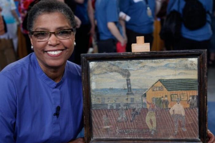 A woman smiling next to a painting.