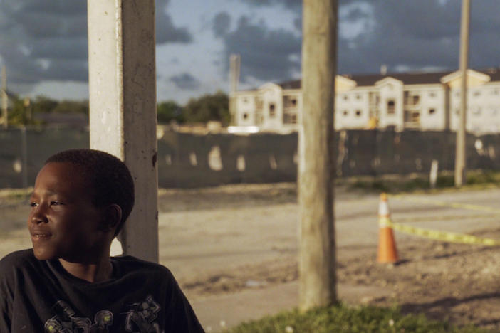 A little boy staring off into the distance with a slight smile.