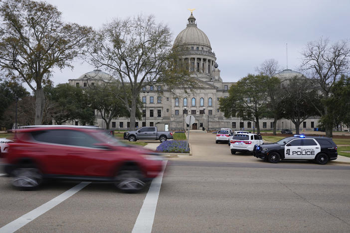 Traffic rolls past the Mississippi State Capitol in Jackson, Miss., as Capitol Police respond to a bomb threat within the building, Wednesday mornin, Jan. 3, 2024. The building was emptied, the grounds cleared of vehicles as officers investigated. 