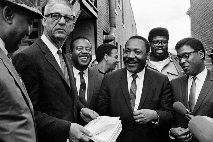 U.S. Marshal Cato Ellis serves Dr. Martin Luther King and his aides with a temporary restraining order barring them from leading another march without court approval, outside the Lorraine Hotel in Memphis, Tennessee, on April 3, 1968. The order was aimed at stopping a march set for April 8 in support of city sanitation workers. Identified people in the photo are Cato, holding papers, Rev. Ralph Abernathy, Andrew Young, in profile and Kin. Others are unidentified.