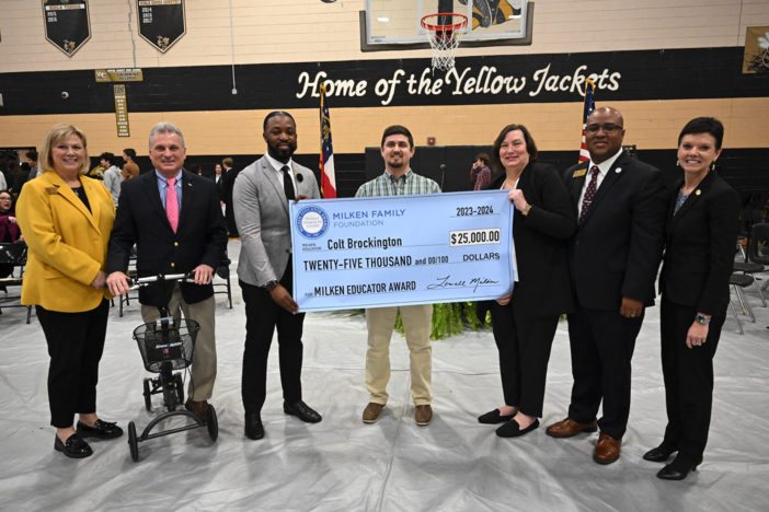 Colt Brockington holds $25,000 check from the Milken Family Foundation.