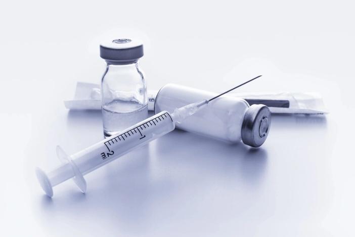 a syringe and vials of vaccine