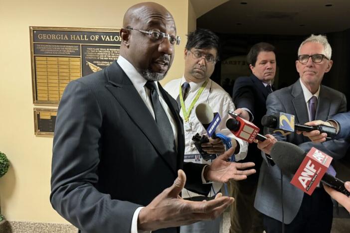 U.S. Sen. Raphael Warnock talks to reporters at the state Capitol Tuesday.