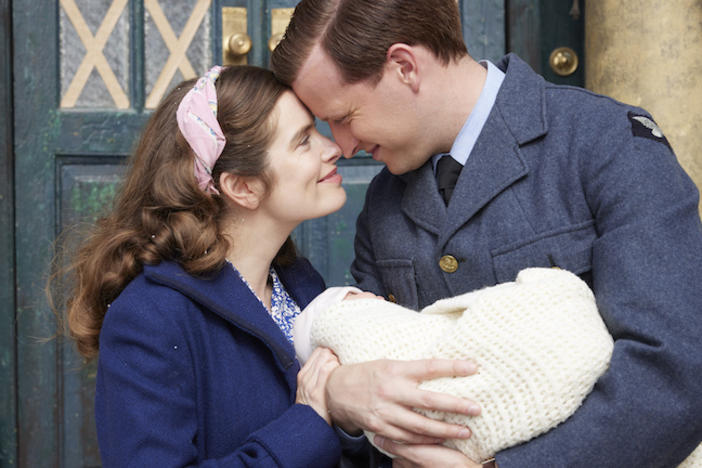 A couple holding a baby and looking lovingly at one another. From All Creatures Great and Small.