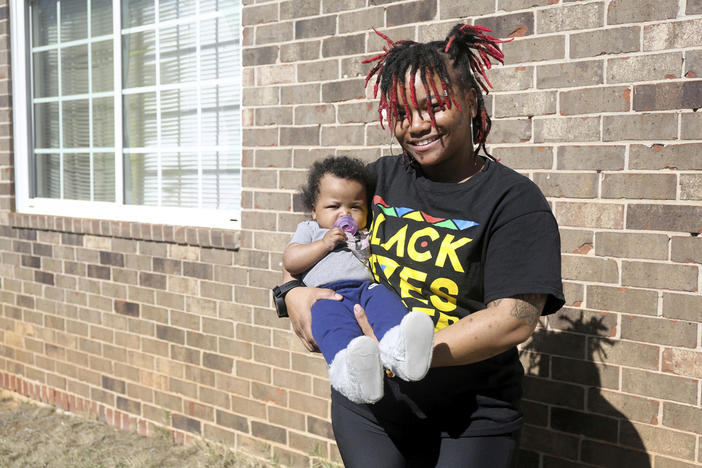 Nia Thomas stands in front of her Atlanta home on Feb. 14, 2024. Thomas was bailed out of jail by the nonprofit Barred Business in May 2022 through the “Mama’s Day Bail Out,” initiative, a practice that could be significantly restricted, if not criminalized, under a recently passed Georgia bill. (AP Photo/R.J. Rico)