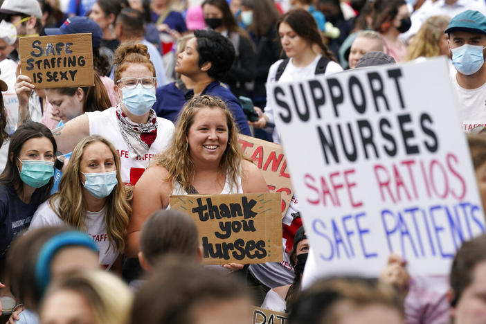 A group of advocates with signs supporting nurse to patient staffing minimums.